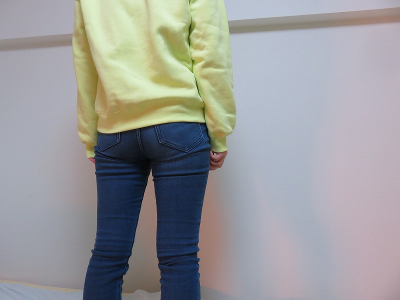 セキュリティポーチの「セキュリポラージサイズ」を女性が服の下の背中側につけた様子