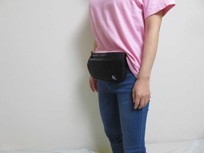 セキュリティポーチの「セキュリポラージサイズ」を女性が服の上のお腹側につけた様子
