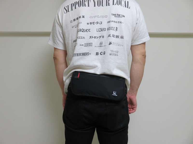 セキュリティポーチの「セキュリポラージサイズ」を男性が服の上の背中側につけた様子