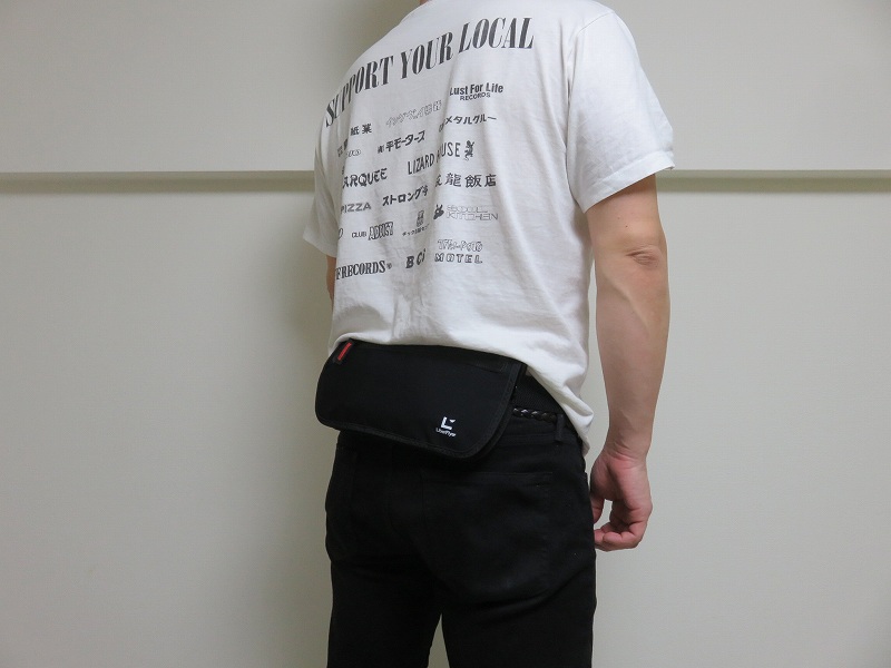 セキュリティポーチの「セキュリポラージサイズ」を男性が服の上の背中側につけた様子